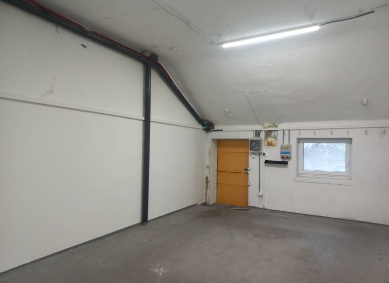 Innenraum der Produktionsräume mit weißen Wänden und einem Fenster mit Gitter.