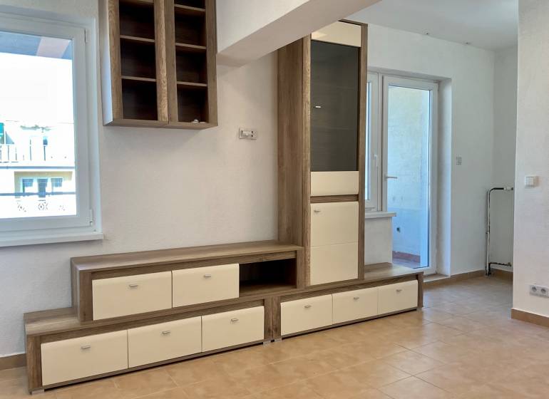 Wohnbereich in einer Einzimmerwohnung mit Möbeln und Keramikboden.