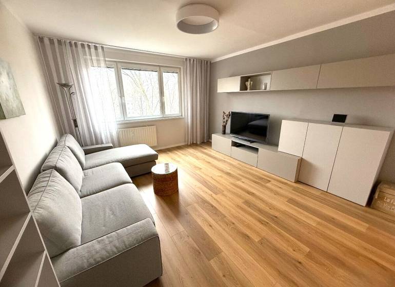 Wohnzimmer einer 3-Zimmer-Wohnung mit Sofa und Holzboden.