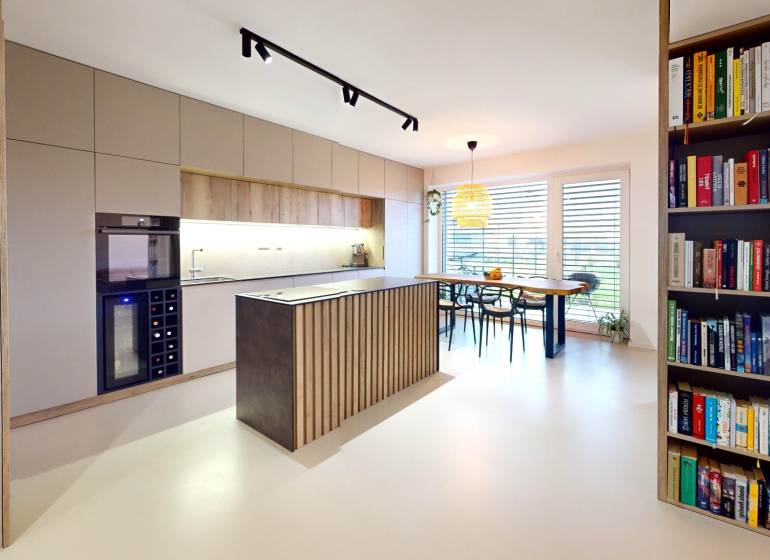 Offene Küche mit Esstisch und Bücherregal in einem Einfamilienhaus.