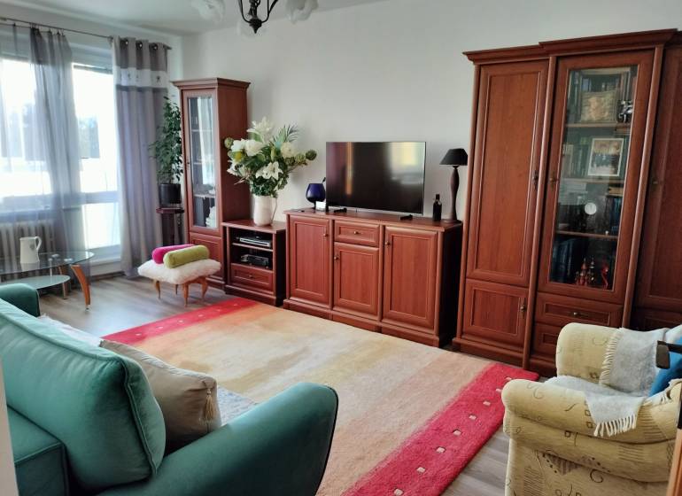 Wohnzimmer in einer Zweizimmerwohnung mit Holzboden und bequemen Möbeln.