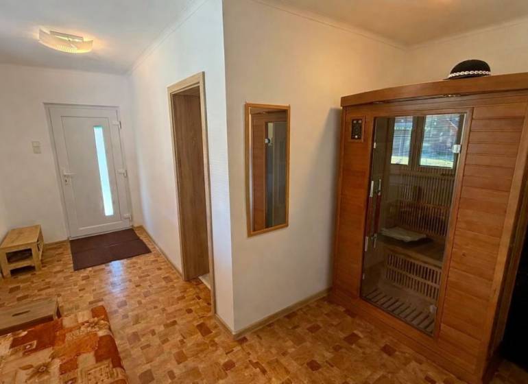 Flur in einem Einfamilienhaus mit Holzboden und eingebauter Sauna.