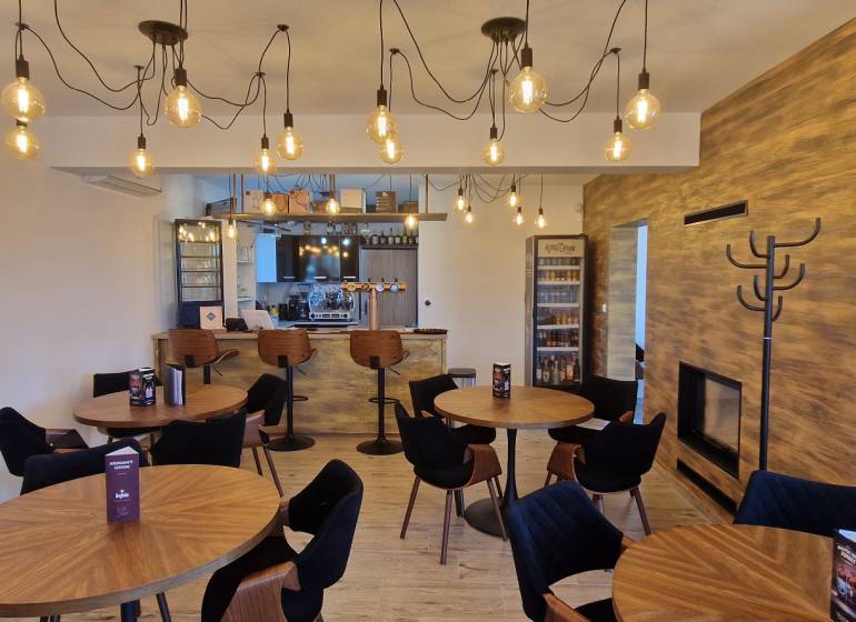 Gastronomiebereiche mit Holzboden und hängenden Glühbirnen.