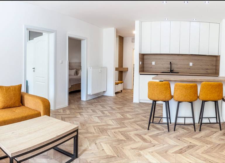 Ferienwohnung mit Sofa, Küchentheke und Holzboden.