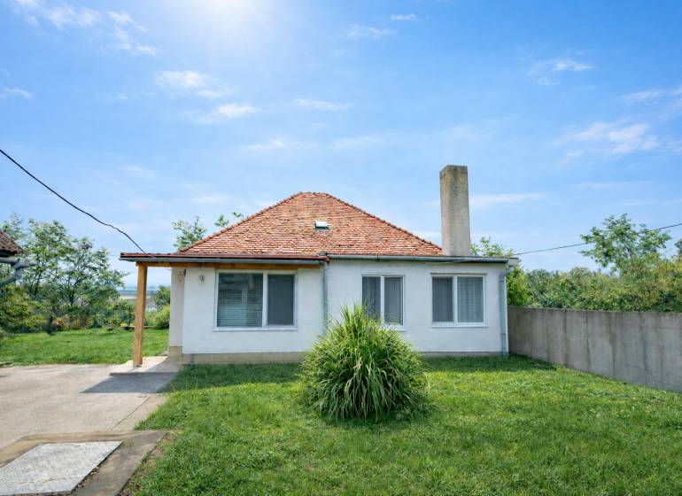 Ein Einfamilienhaus in Veľké Ripňany mit Garten, Schrägdach und Rasenhof.