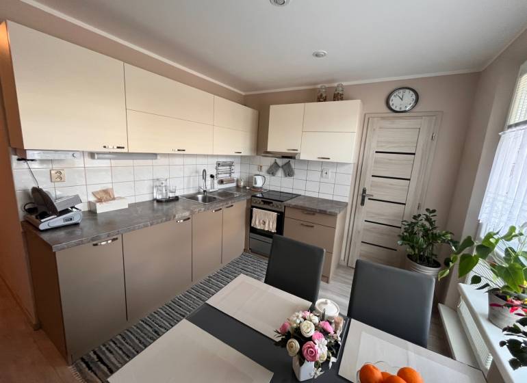 Küche in einer 3-Zimmer-Wohnung mit hellen Schränken und Esstisch.