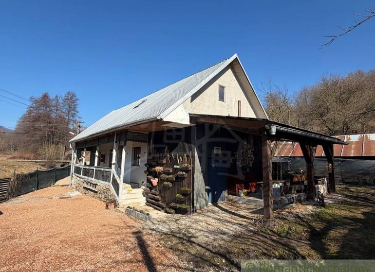 Ein Einfamilienhaus in Ratkovské Bystré mit einem Satteldach und einer Holzveranda.