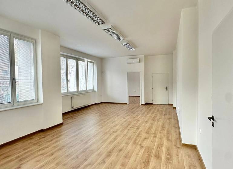 Büros mit Holzboden, weißen Wänden und Fenstern bieten einen hellen Arbeitsbereich.