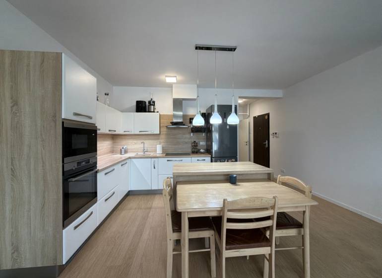 Küche in einer 3-Zimmer-Wohnung mit Holzboden und Esstisch.