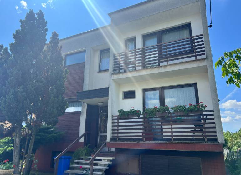 Einfamilienhaus in der Tálová-Straße in Veľké Orvište mit zwei Balkonen, Bäumen und einer Garage.