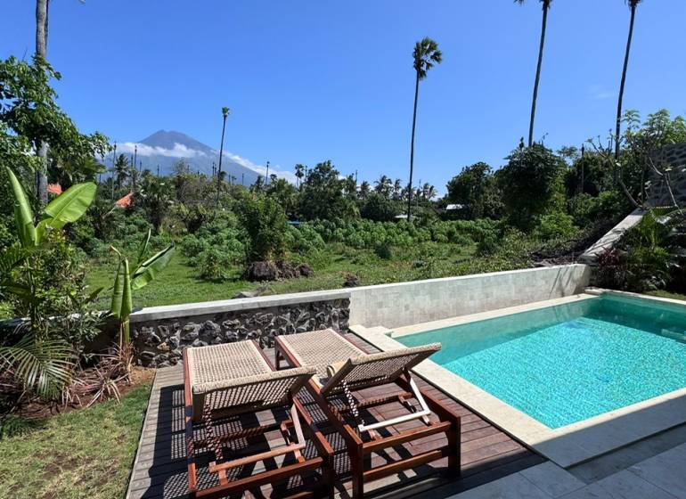 Liegen und Liegestühle mit Blick auf das Grün in der Amedská-Straße, Amed, neben einem Einfamilienhaus.