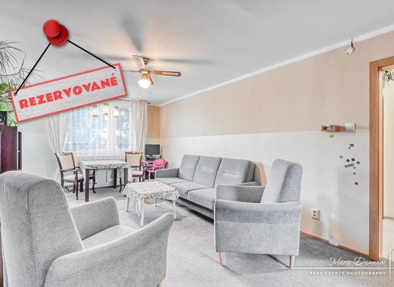 Wohnzimmer in einer 4-Zimmer-Wohnung mit bequemen Sesseln und einem Essbereich.