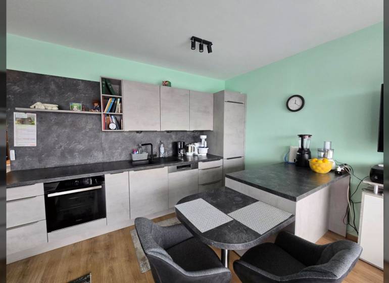 Küche mit Esstisch und Boden in Holzoptik im Ferienapartment.