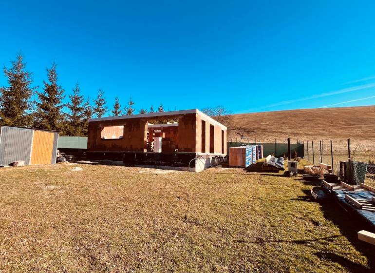 Der Bau von Häusern in Prosačov in der Prosačova-Straße, umgeben von Natur und klarem Himmel.