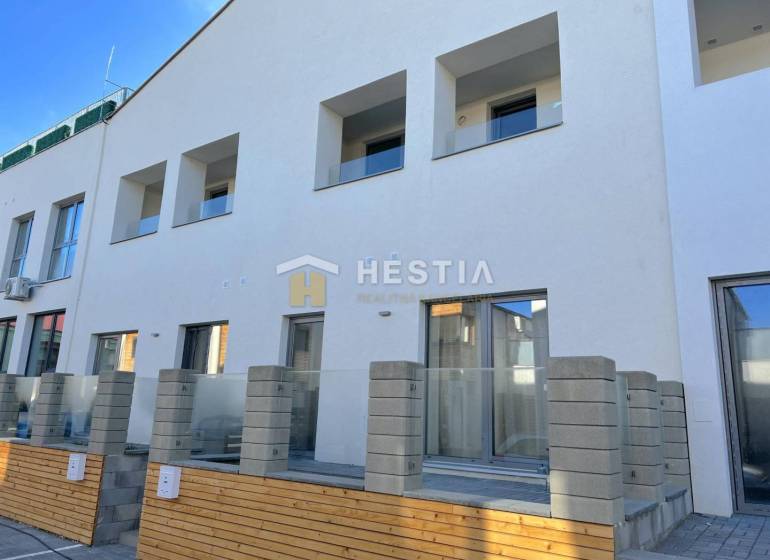 Neubau mit mehreren Balkonen und einer 2-Zimmer-Wohnung, Betonzaun und Terrasse.