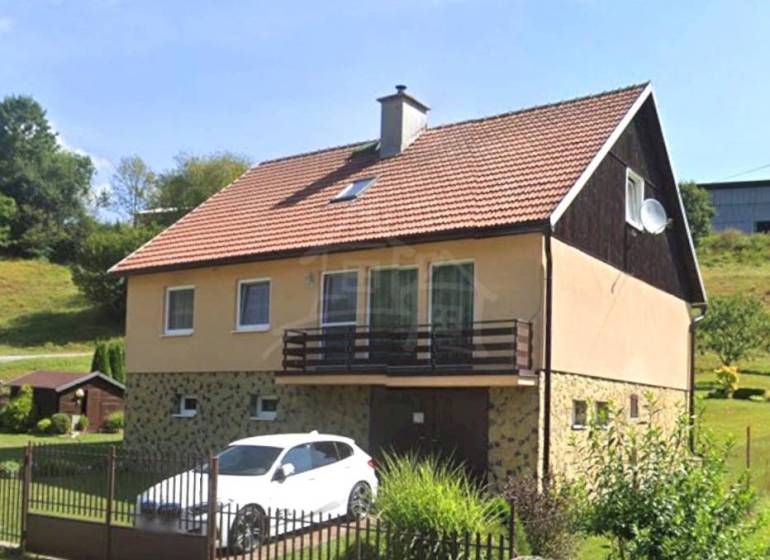 Ein Einfamilienhaus in Liptovské Revúce mit Garage und Garten auf einem Hanggrundstück.
