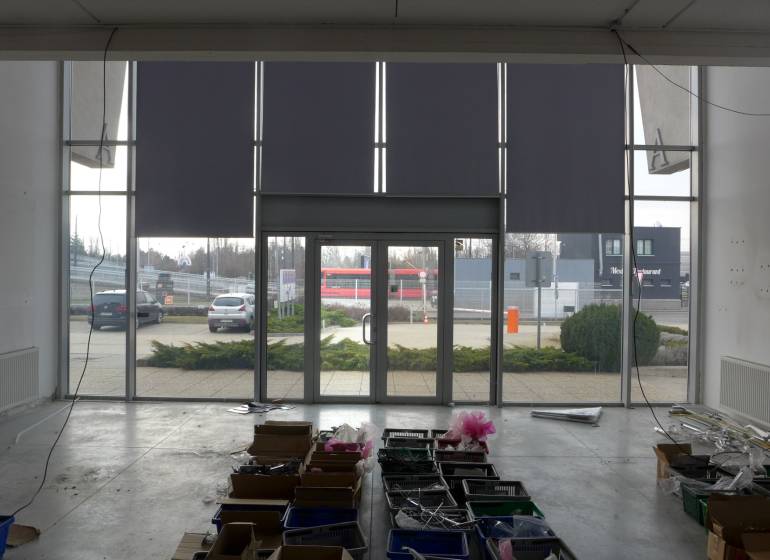 Innenraum von Geschäftsräumen in Bratislava mit großen Glastüren und Aufbewahrungsboxen.