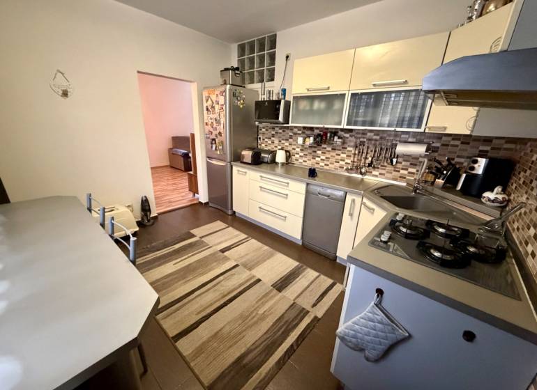 Küche in einer 3-Zimmer-Wohnung mit einem Gasherd und Fliesenverkleidung.