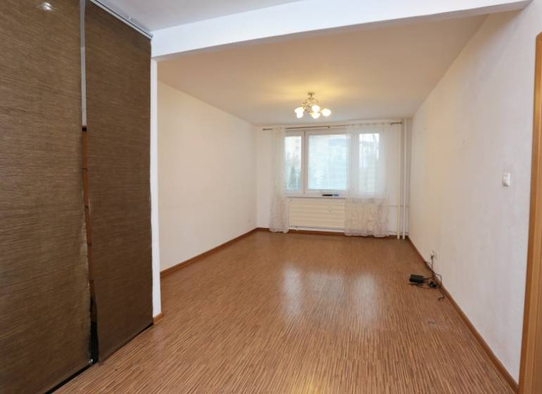 Wohnzimmer mit Vorhängen und Holzboden in einer 3-Zimmer-Wohnung.