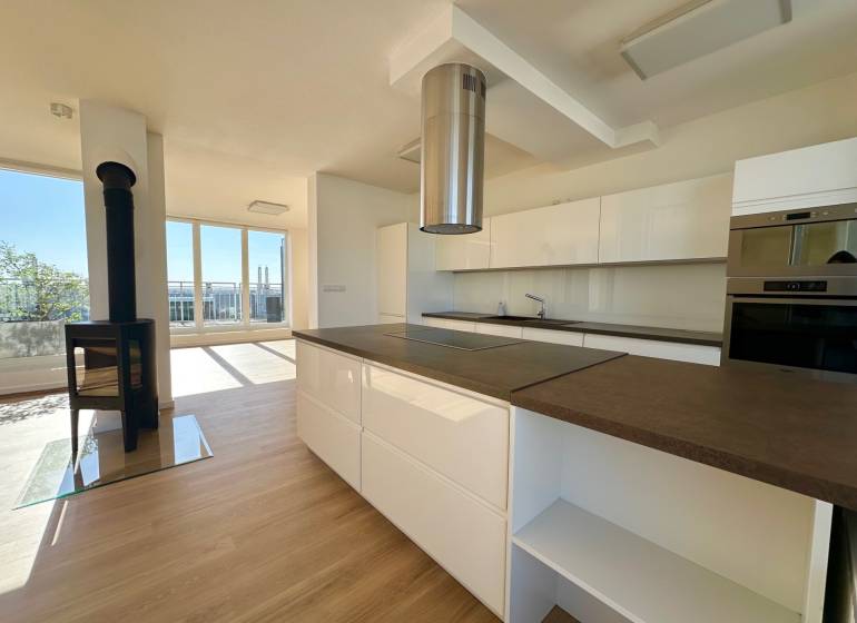 Küche in einer 4-Zimmer-Wohnung mit Kamin und Boden in Holzoptik.