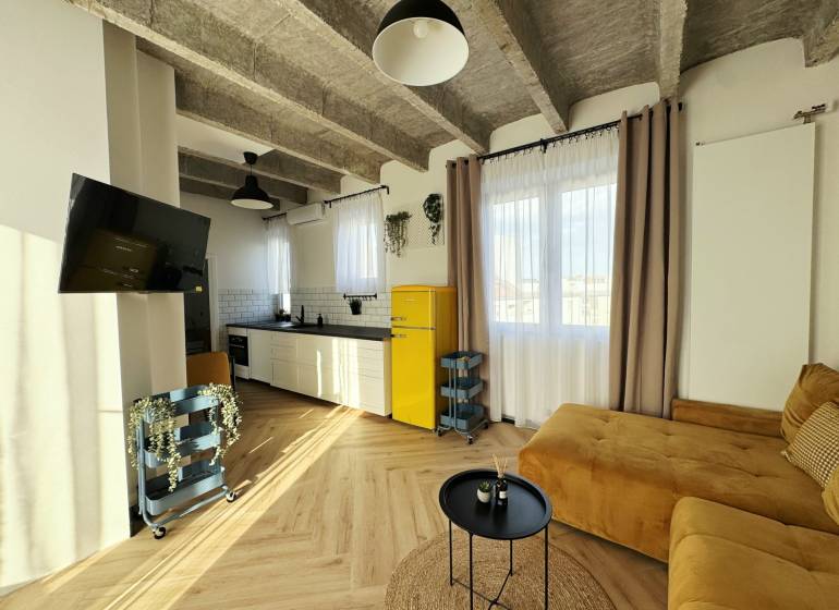 Wohnzimmer in einer 3-Zimmer-Wohnung mit Holzboden und gelbem Kühlschrank.