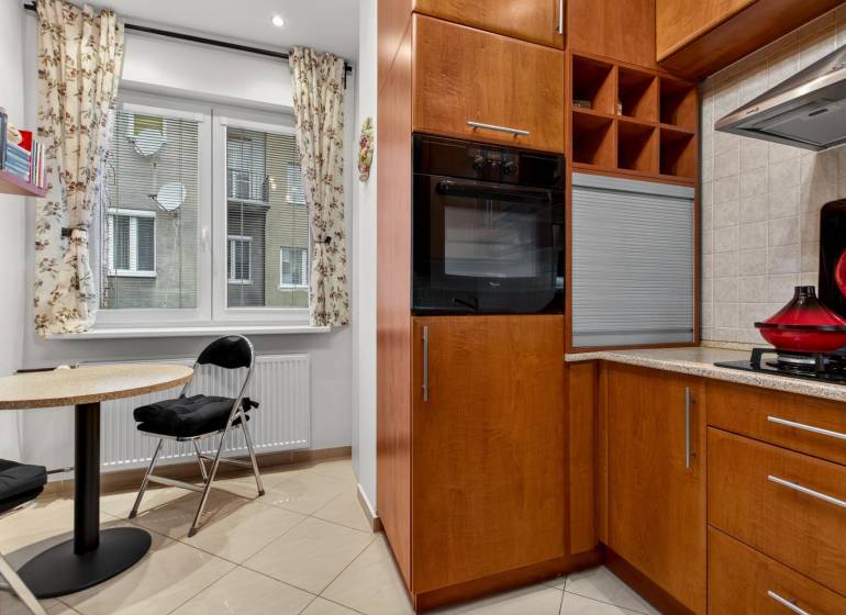 Küche in einer 3-Zimmer-Wohnung mit Essecke und Holzdekor der Schränke.