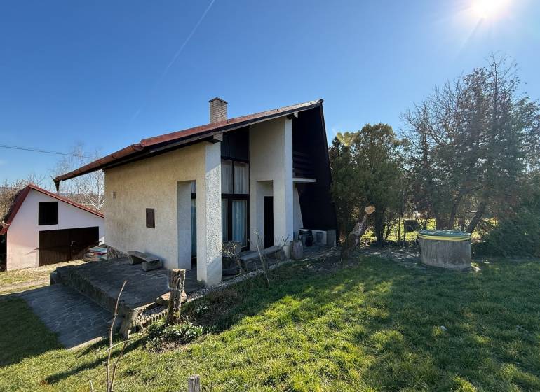 Ein Ferienhaus in Zlaté Moravce, umgeben von einem Garten und Rasen unter klarem Himmel.