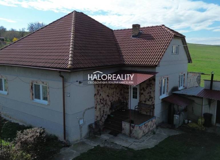 Ein Einfamilienhaus in Rimavské Janovce mit rotem Dach und ländlicher Umgebung.