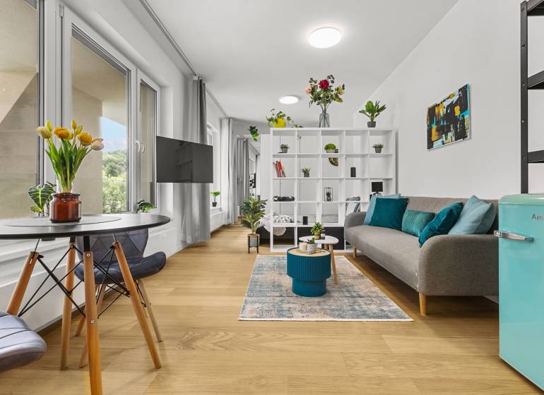Helle 1-Zimmer-Wohnung mit Holzboden, Sofa und Essecke.