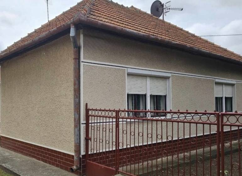 Ein Einfamilienhaus in Radava in der Hauptstraße mit rotem Dach und weißen Fensterläden.