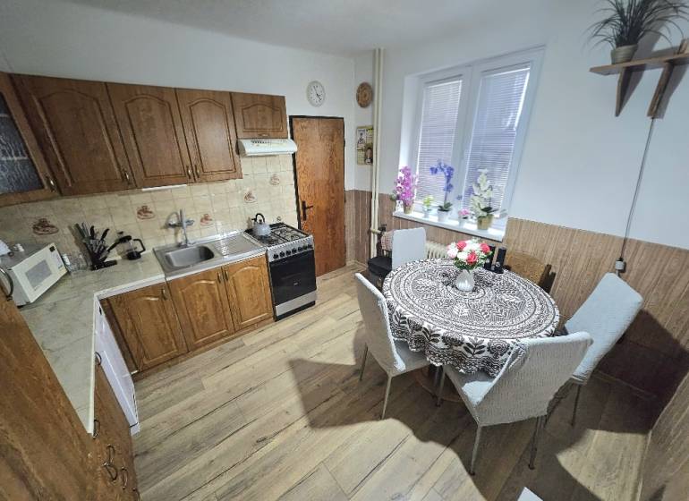 Küche in einem Einfamilienhaus mit Holzdekor, mit Esstisch und Küchenzeile.