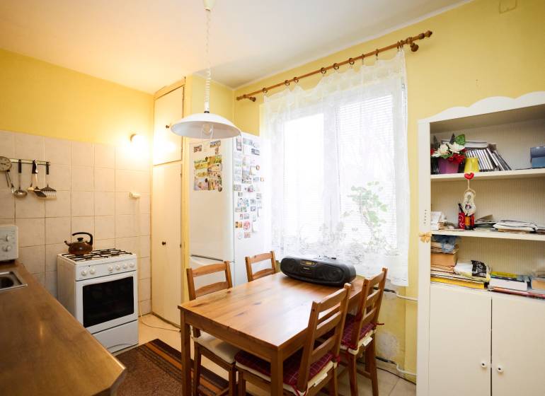 Küche in einer 3-Zimmer-Wohnung mit Tisch, Stühlen und Küchenzeile.