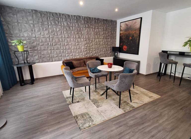 Wohnzimmer mit Sesseln und Sofa in einem Einfamilienhaus, dekorative Wand und Bartheke.