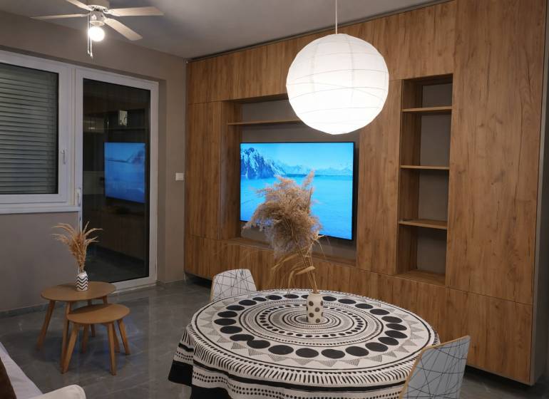 Wohnzimmer in einer 2-Zimmer-Wohnung mit Holzboden und rundem Tisch.