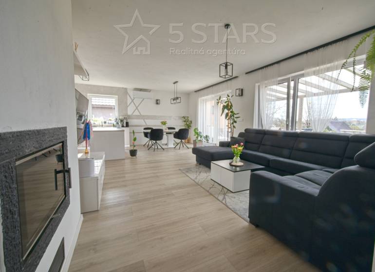 Wohnzimmer in einem Einfamilienhaus mit großem Sofa und Holzboden.