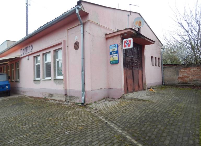 Rosa Gebäude in Búča mit der Aufschrift 