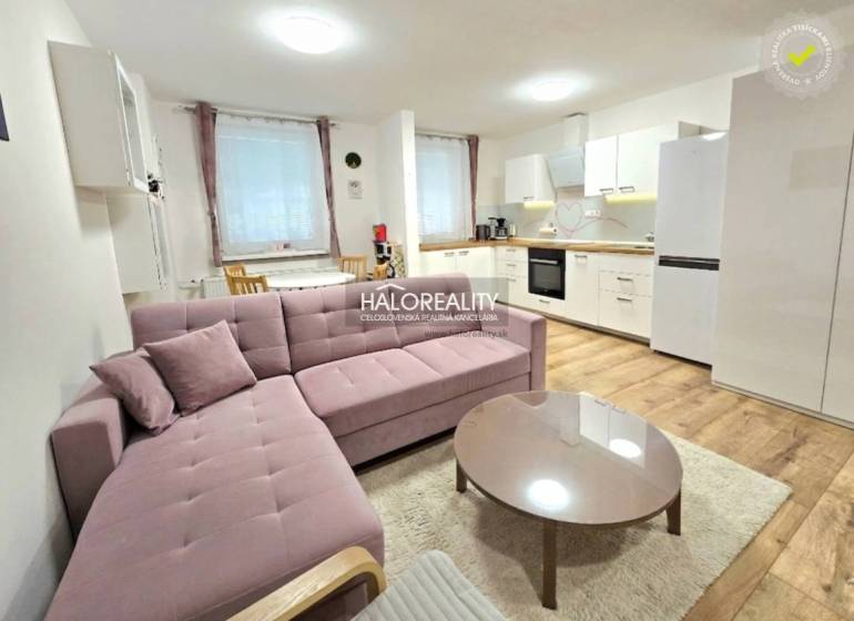 Das Wohnzimmer mit Küche in der 3-Zimmer-Wohnung verbindet ein bequemes Sofa und eine Küchenzeile.