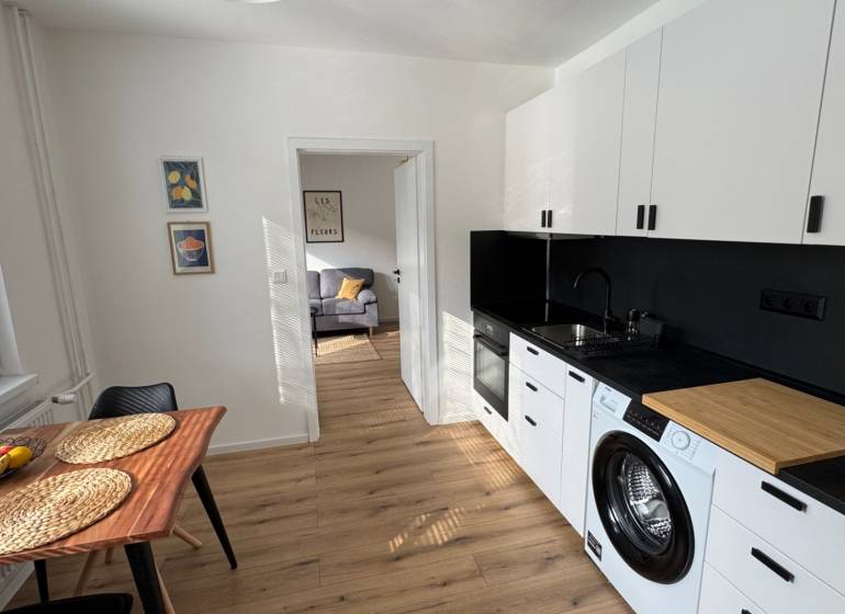 Küche in einer Einzimmerwohnung mit Ausstattung und Boden in Holzoptik.