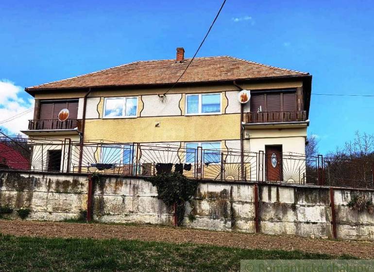 Ein Einfamilienhaus in Kiarov mit einer gemauerten Umzäunung und einer Satellitenschüssel.