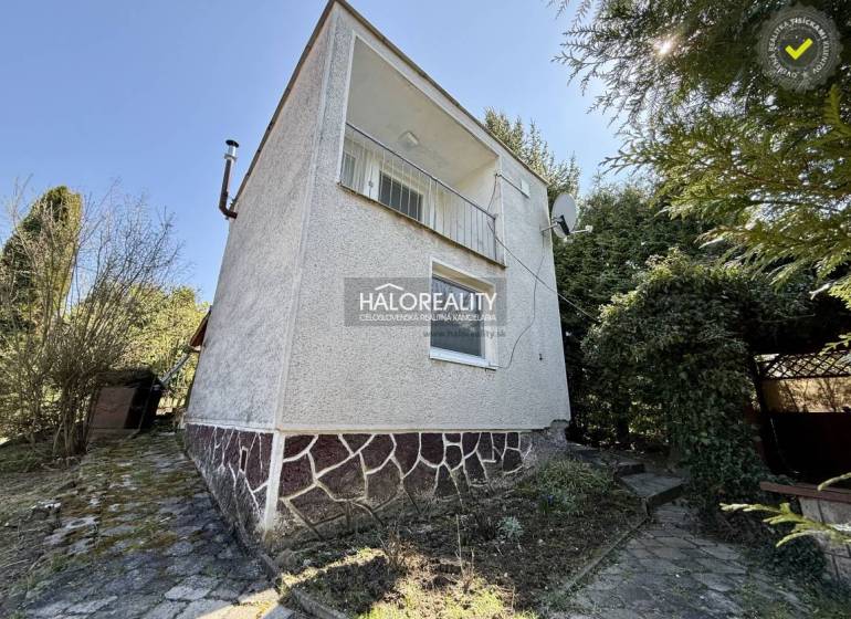 Ein Einfamilienhaus umgeben von Bäumen und Sträuchern in den Gärten der Stadt Rimavská Sobota.