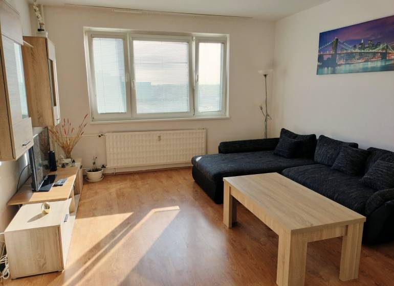 Wohnzimmer mit Sofa, Couchtisch und Holzboden in einer 3-Zimmer-Wohnung.
