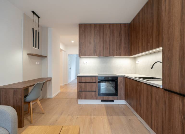 Küche in einer 3-Zimmer-Wohnung mit Holzdekor und stilvoller Beleuchtung.