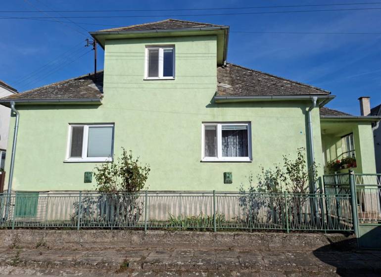 Ein Einfamilienhaus in Malé Leváre mit einer hellgrünen Fassade und einem steilen Dach.