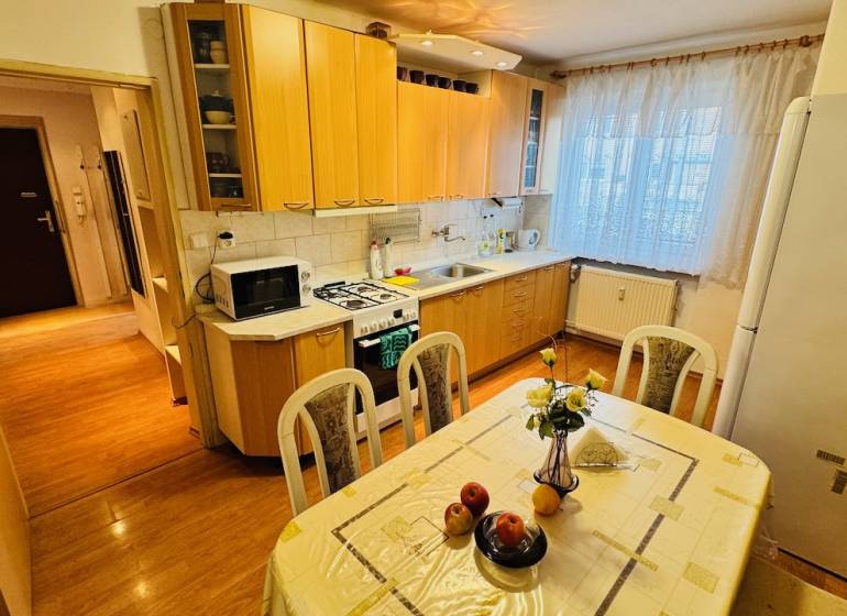 Küche in einer 3-Zimmer-Wohnung mit Holzboden und Esstisch.