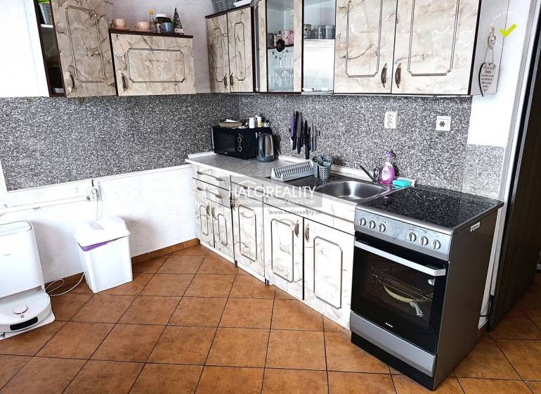 Küche mit Fliesen und Küchenzeile in einer 2-Zimmer-Wohnung.