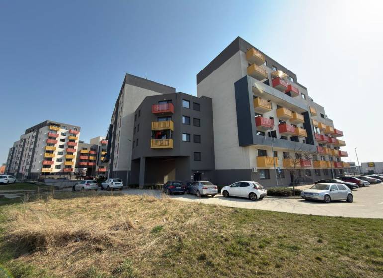 Wohnhäuser in der Mikovíniho-Straße in Trnava mit Parkplatz und Grünfläche.