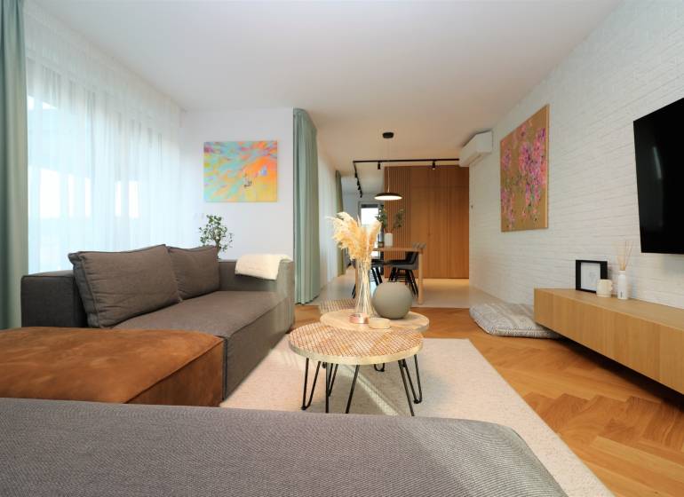Stilvolles Wohnzimmer in einer 4-Zimmer-Wohnung mit Holzboden und Kunstgemälden.