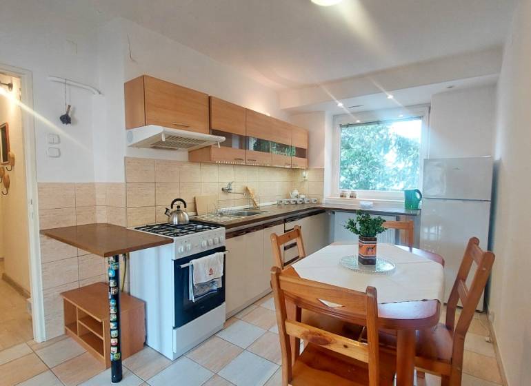 Küche mit Küchenzeile und Esstisch in einer 2-Zimmer-Wohnung.