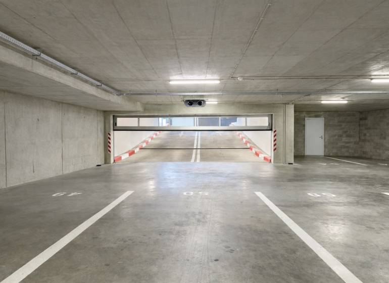 Parkplätze in Garagen mit Rampe und weißer Markierung.