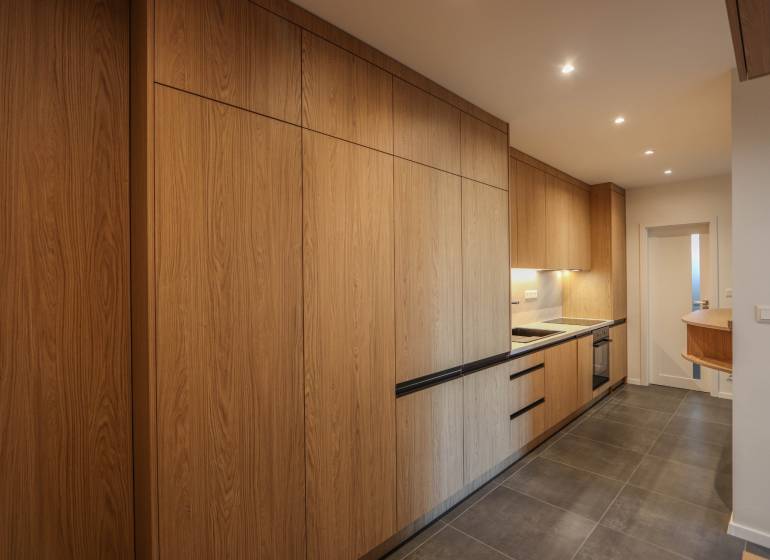 Küche in einer 3-Zimmer-Wohnung mit Holzboden und eingebauten Geräten.